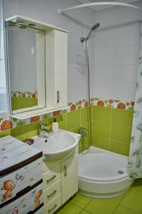 a bathroom with a sink and a shower and a toilet at Vacation home Lubov in Kamianets-Podilskyi