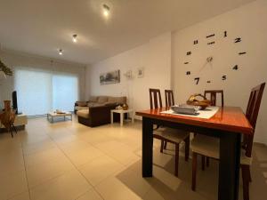 een woonkamer met een tafel en een klok aan de muur bij 70m2 Apt 2bedrooms 25m2Terrace, 4Pools, 3min beach in Lloret de Mar