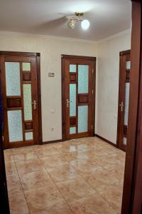 an empty room with doors and a tile floor at Vacation home Lubov in Kamianets-Podilskyi