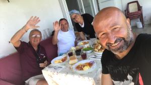 a group of people sitting around a table eating food at Wifi Hafta sonu kaçamağı wifi in Gelibolu
