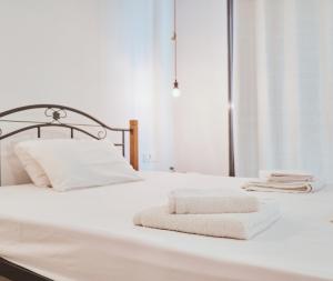 a white bed with two towels on it at Zanteapts 360 Gouzeli Apartment in Zakynthos Town