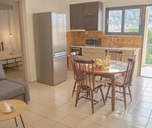 a kitchen with a table and chairs and a refrigerator at Zanteapts 360 Gouzeli Apartment in Zakynthos Town