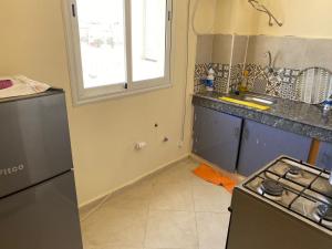 een keuken met een fornuis, een wastafel en een raam bij Safi city apartment in Safi