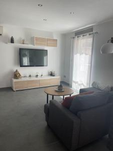 a living room with a couch and a table at Maison sud de France avec jacuzzi et sauna privé in Villeneuve-lès-Maguelonne