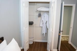 a room with a closet with a robe and a bed at Luxury 3BR Townhome in the Heart of Winston Salem NC - Sleep 6 in Winston-Salem