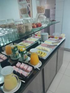 a buffet line with many different types of food at Hotel Conexão Pampulha in Belo Horizonte