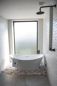 a white bath tub in a bathroom with a window at FULTON Business Luxury HOTEL in Guadalajara