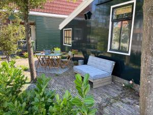 een patio met een blauwe bank en een tafel bij Boutique B&B Dolce Due in Assendelft