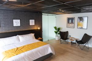 a bedroom with a large bed and two chairs at FULTON Business Luxury HOTEL in Guadalajara