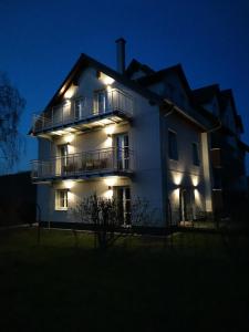una casa blanca con luces encendidas por la noche en Ferienwohnung Meyer Obergeschoss, en Weissenburg in Bayern