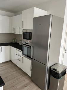 a stainless steel refrigerator in a kitchen with white cabinets at Beautiful 2 Bedroom Apartment in Prostějov