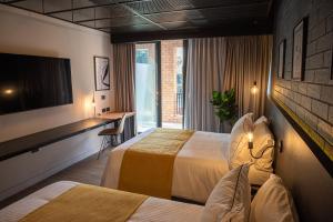 a hotel room with two beds and a television at FULTON Business Luxury HOTEL in Guadalajara