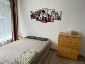 a bedroom with a bed and a dresser with pictures on the wall at Beautiful 2 Bedroom Apartment in Prostějov