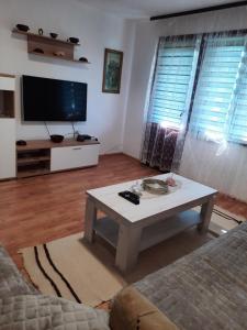 a living room with a coffee table and a flat screen tv at Apartman Petković in Višegrad