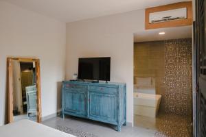 a bedroom with a blue cabinet with a television on it at Hotel Del Portal San Miguel de Allende in San Miguel de Allende