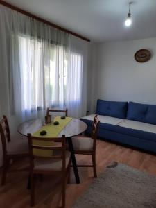 ein Wohnzimmer mit einem Tisch und einem blauen Sofa in der Unterkunft Apartman Petković in Višegrad