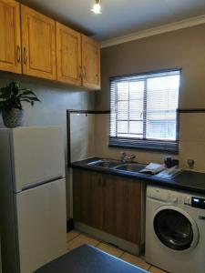 a kitchen with a sink and a washing machine at Private Apartment for business and leisure Pretoria East in Pretoria