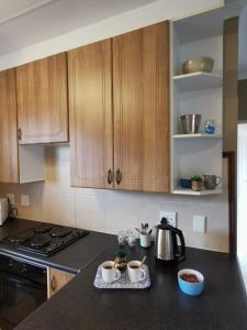 a kitchen with wooden cabinets and a counter top at Private Apartment for business and leisure Pretoria East in Pretoria