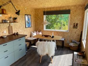 a dining room with a table and a window at Cozy Tiny House on a farm in Skibby