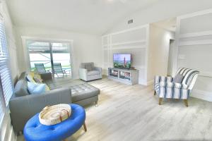 a living room with a couch and a tv at Jupiter Sunshine in Jupiter