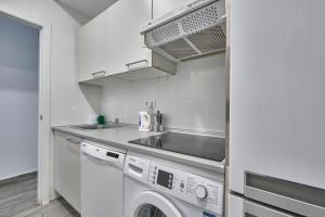 cocina con fregadero y lavadora en Núñez de Arce habitaciones, en Madrid