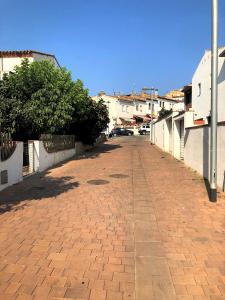 una strada vuota con marciapiede in mattoni e edifici di Casa en Palamós (Costa Brava). Unifamiliar, 3 BDRM, 6 Pers, Garage a Palamós