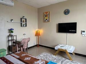 a living room with a flat screen tv on the wall at Oak Cottage in Dar es Salaam