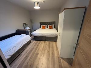 a bedroom with two beds with orange pillows at Knockreagh Farm Cottages Mountain or Cedar views in Kilkenny