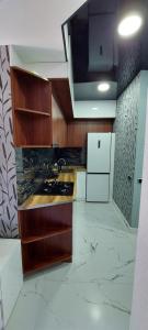 kuchnia z drewnianymi szafkami i białą lodówką w obiekcie New apartments in borjomi w Bordżomi