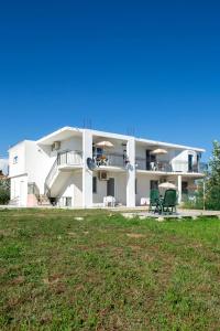 a large white building with a lawn in front of it at Aida Apartments in Ulcinj