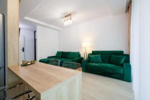 a living room with green furniture and a couch at Green Luxury Apartment Lake On in Mamaia