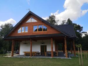 a large wooden house with a picnic table in front of it at Dom Na Korzeniu 
