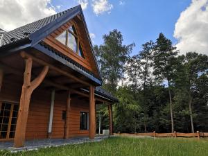 a log cabin with a gambrel roof at Dom Na Korzeniu 