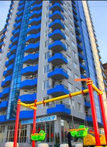 um grande edifício de apartamentos com um parque infantil em frente em BatumiBliss1 em Batumi