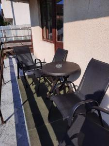 einen Tisch und Stühle an der Seite eines Gebäudes in der Unterkunft Apartman Petković in Višegrad