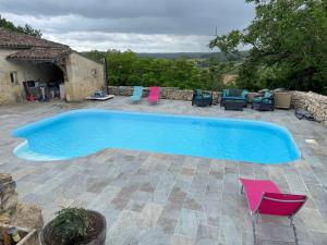 une grande piscine avec des chaises et une maison dans l'établissement Gouillette, à Saint-Pey-de-Castets