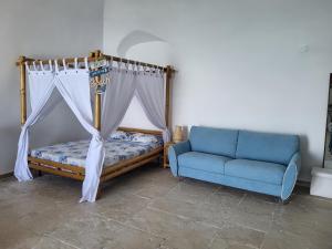 a bedroom with a bed and a blue couch at Nonna Libera Vista Mare in Rodi Garganico