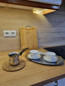 a table with three cups and a pot on a counter at Vikendica River Drina - Mali Zvornik-Velika Reka in Podrebelj