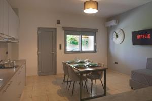 una cucina e una sala da pranzo con tavolo e sedie di Philippos & Alexandros Apartments a Tigaki