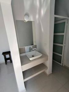 een badkamer met een wastafel en een spiegel bij VillaGera ¡Tu casa en la playa! in Ursulo Galván