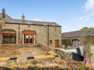 an external view of a stone house with a patio at The Barn in Holmfirth