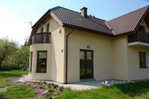 uma pequena casa com uma varanda em cima em Mikołajówka em Stronie Śląskie