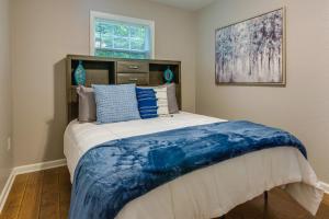 Un dormitorio con una cama con una manta azul. en Searcy Vacation Rental with Deck and Water Views!, en Searcy