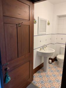 baño con lavabo, aseo y puerta en Advie Lodge, en Inverness