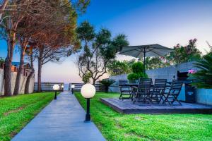 a patio with a table and chairs and an umbrella at Villa Angela in Ágios Matthaíos