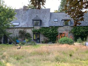 パンポンにあるL'Hôtié de Brocéliande à Paimpont, au coeur des sites naturels et légendairesの鳥の前にある古い石造りの家