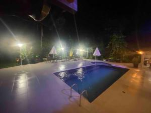 an empty swimming pool at night with lights at Casa Praia Guaratuba - Bertioga in Bertioga
