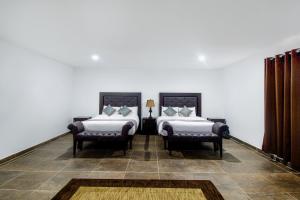 a bedroom with two beds and two chairs at Collection O Hotel Nueva Escocia, Puebla in Puebla