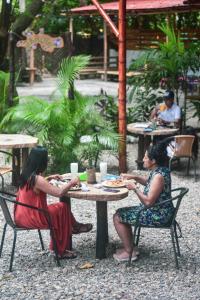 dos mujeres sentadas en una mesa comiendo comida en Kanta Sana, en Palomino