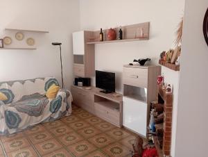 a living room with a couch and a television at Casa vacanze Il Carrubo in Leporano